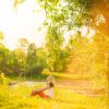 Welke vraag zou mij nu verder helpen? beautiful woman having rest under huge tree in sunset time outside. Sunset people. Lonely woman enjoying nature landscape in evening. Summer or spring day. Girl sitting on grass Color horizontal image